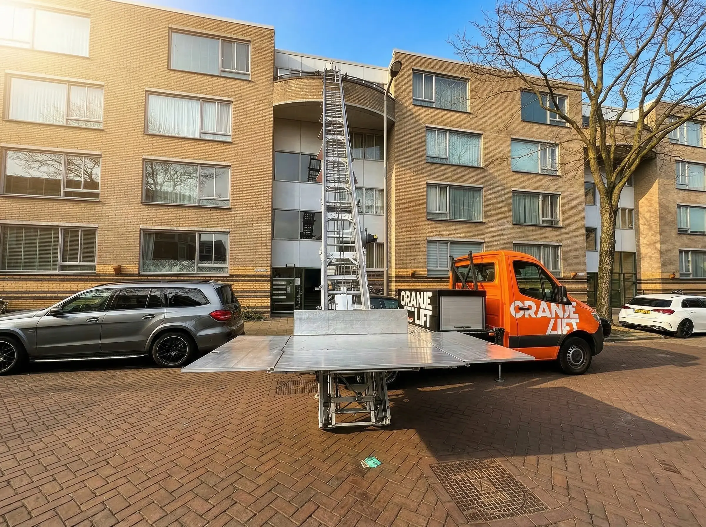 OranjeLift ladderlift opgesteld bij woning in Utrecht, liftplatform op weg naar boven voor verhuizing