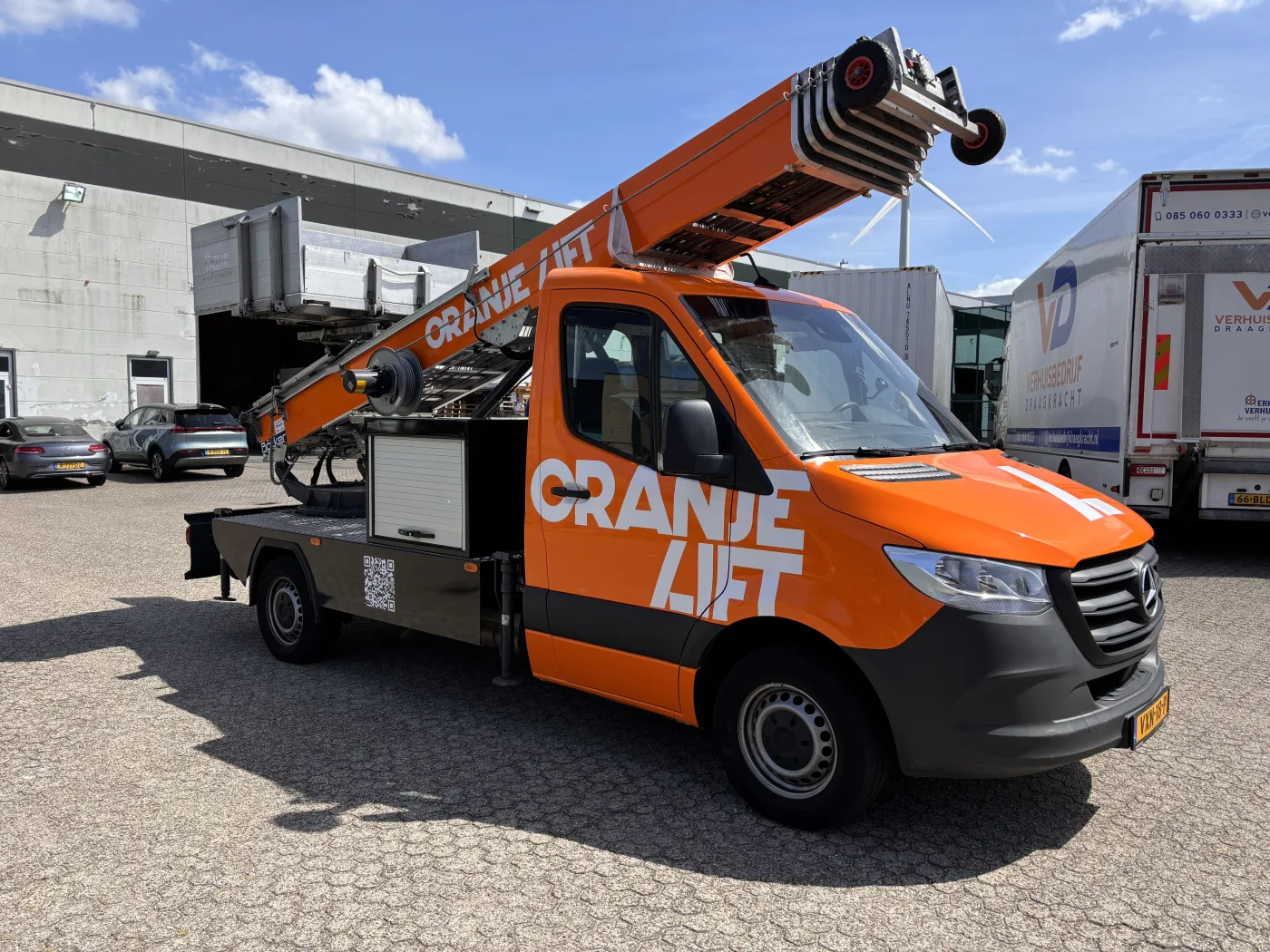 OranjeLift operator helpt meubels via de verhuislift